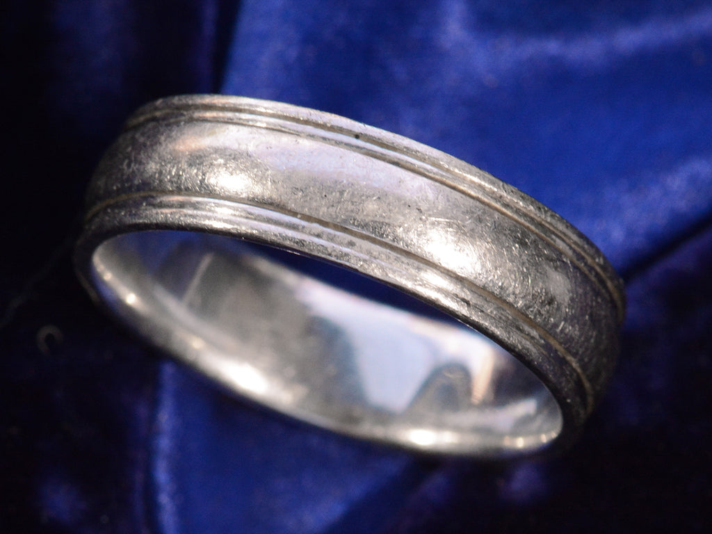 Angled view detail of c1980 Striped Platinum Band (on dark blue background)