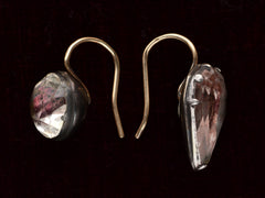 thumbnail of Side view of mismatched earrings made from pink foiled silver set buttons on gold ear wires. On black background.