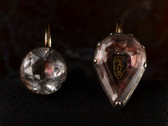 thumbnail of Front view of mismatched earrings made from pink foiled silver set buttons on gold ear wires. On black background.