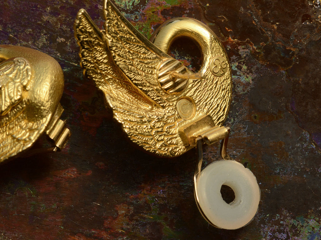 Detail reverse side view of of vintage swan-shaped 18K yellow gold earrings, showing posts and backs and "CG" hallmark for Charles Garnier.