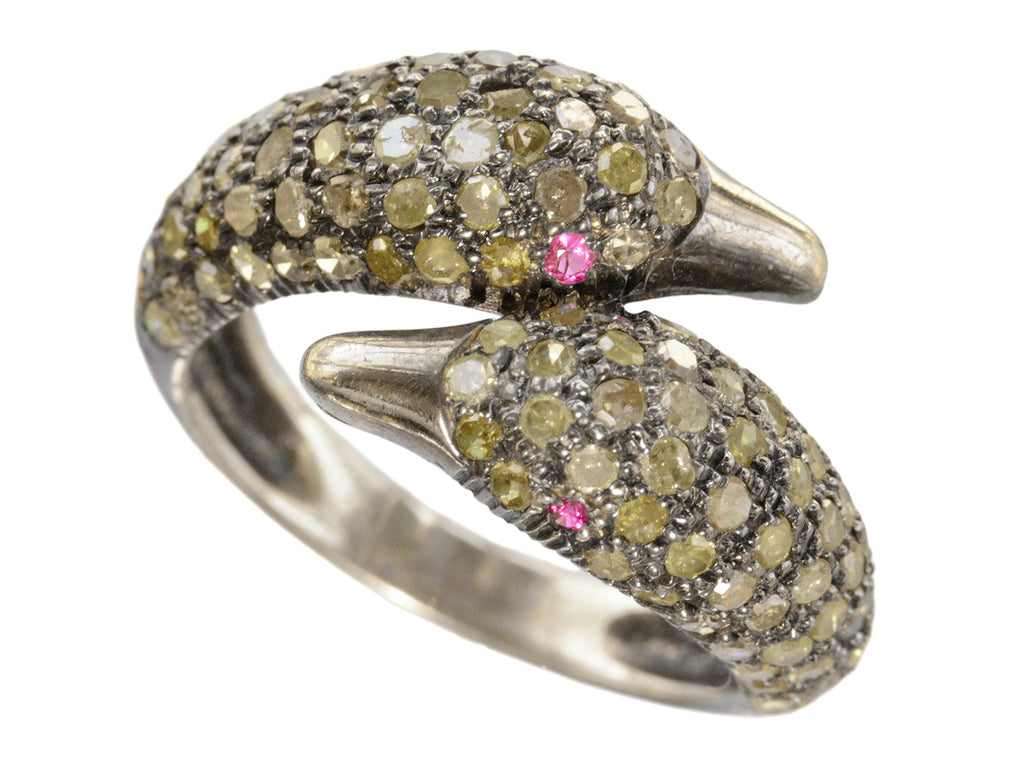 Figural ring with two swan heads, set with light yellow diamonds and ruby eyes in silver, shown on white background.