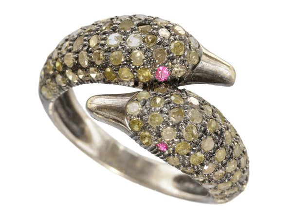 Figural ring with two swan heads, set with light yellow diamonds and ruby eyes in silver, shown on white background.