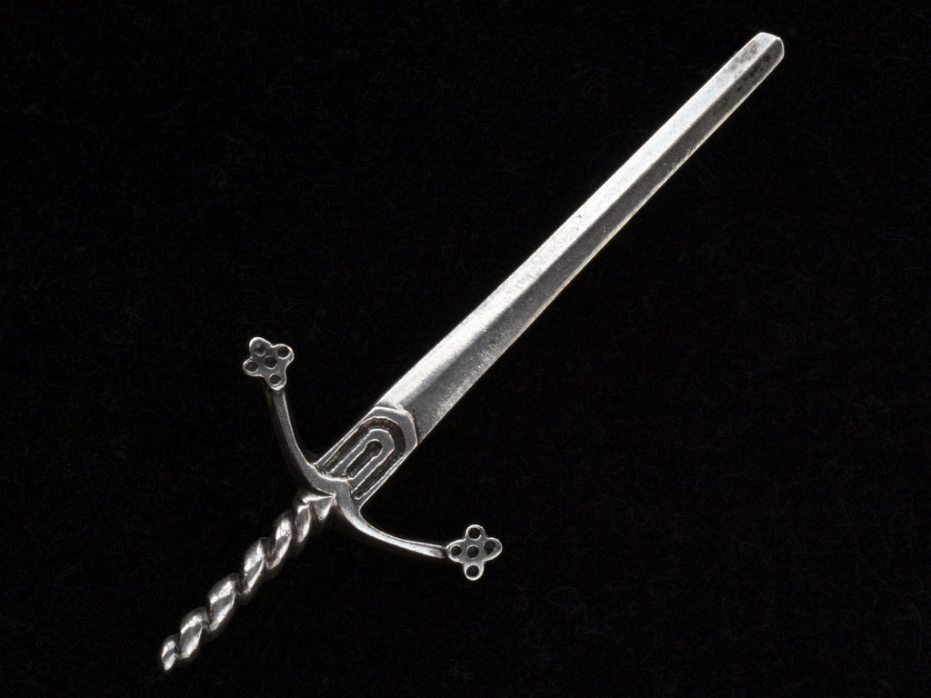 Large silver sword brooch on black background.