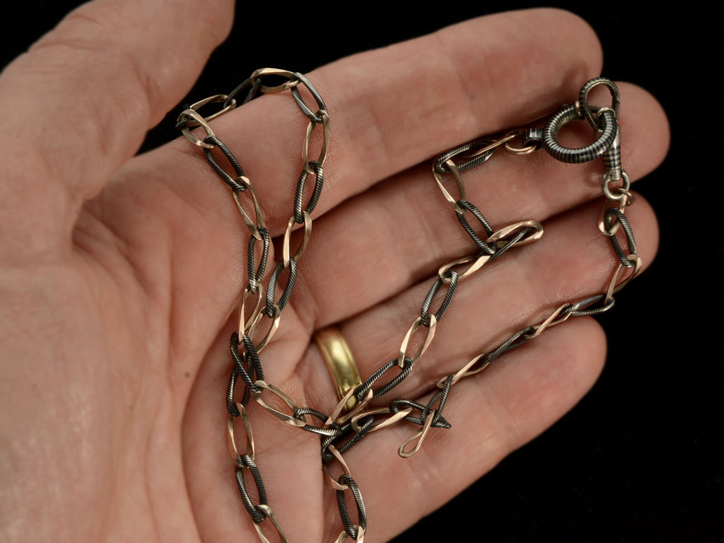 Detail view of c1900 Thin Antique Chain of Alternating Links of Gilt Silver and Striped Niello (shown on hand)
