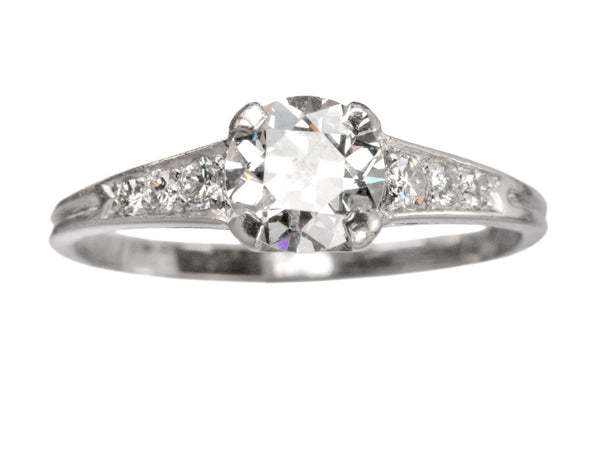 A c1930 Art Deco Tiffany & Co platinum engagement ring with a round old cut diamond and three smaller diamonds on each shoulder, tapering in size shown on white background.