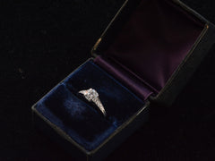 thumbnail of A c1930 Art Deco Tiffany & Co platinum engagement ring with a round old cut diamond and three smaller diamonds on each shoulder, tapering in size shown in its original navy blue and purple ring box. 