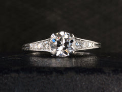 thumbnail of Front view of a c1930 Art Deco Tiffany & Co platinum engagement ring with a round old cut diamond and three smaller diamonds on each shoulder, shown on dark background
