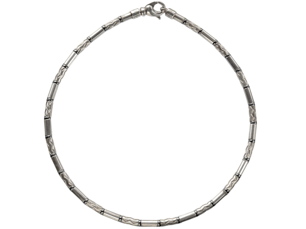 A vintage Tiffany "Aztec" necklace with barrel-shaped sterling silver beads interspersed with narrow bands of hematite and alternating with zig-zag embellished beads, shown on white background.