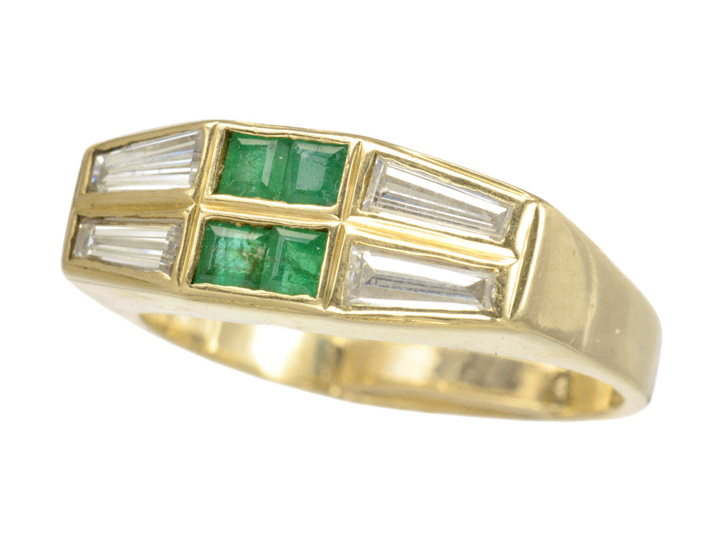 Angled view of vintage yellow gold Tiffany ring with four square emeralds and four tapered diamond baguettes.  Shown on white background.