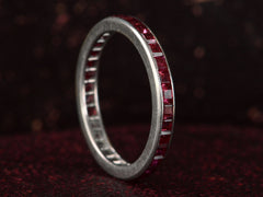 thumbnail of Angled view of c1950 Tiffany & Co platinum eternity band  with square cut rubies on dark textured background.