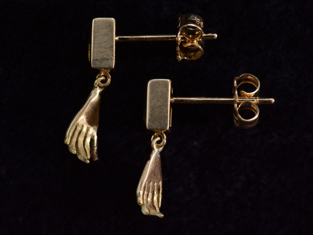 Side profile view of EB Modern Earrings with Rectangular Olive Colored Tourmaline Tops and Hand Pendants in Yellow Gold (shown on dark background)