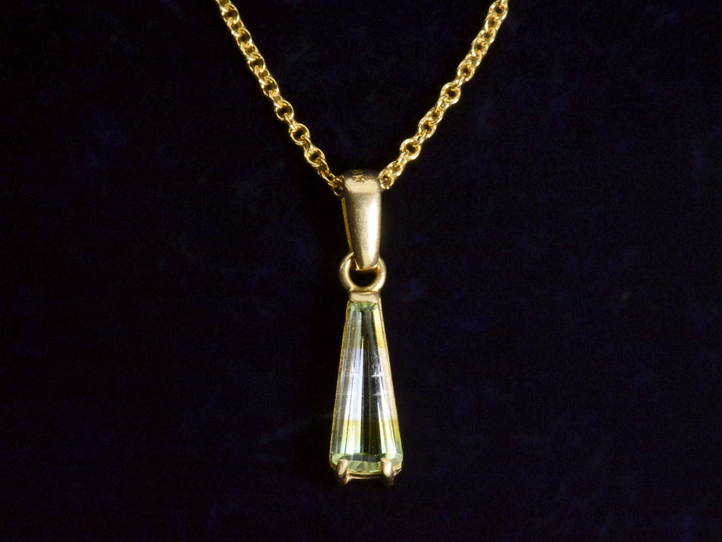Front detail of c1980 Green and White Tourmaline Pendant in Yellow Gold. On dark background.