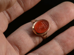 thumbnail of 1891 Ring with oval orange carnelian intaglio of a tree set in rosy-yellow gold, shown on finger.