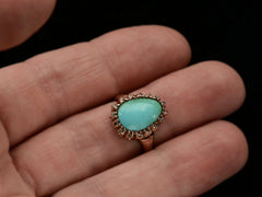 thumbnail of Antique rose gold ring with egg shaped turquoise surrounded by small rose cut diamonds, shown on hand.