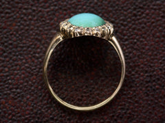 thumbnail of Side profile of antique rose gold ring with egg shaped turquoise surrounded by small rose cut diamonds, shown on dark textured background.