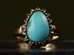 thumbnail of Front view of antique rose gold ring with egg shaped turquoise surrounded by small rose cut diamonds, shown on dark background.