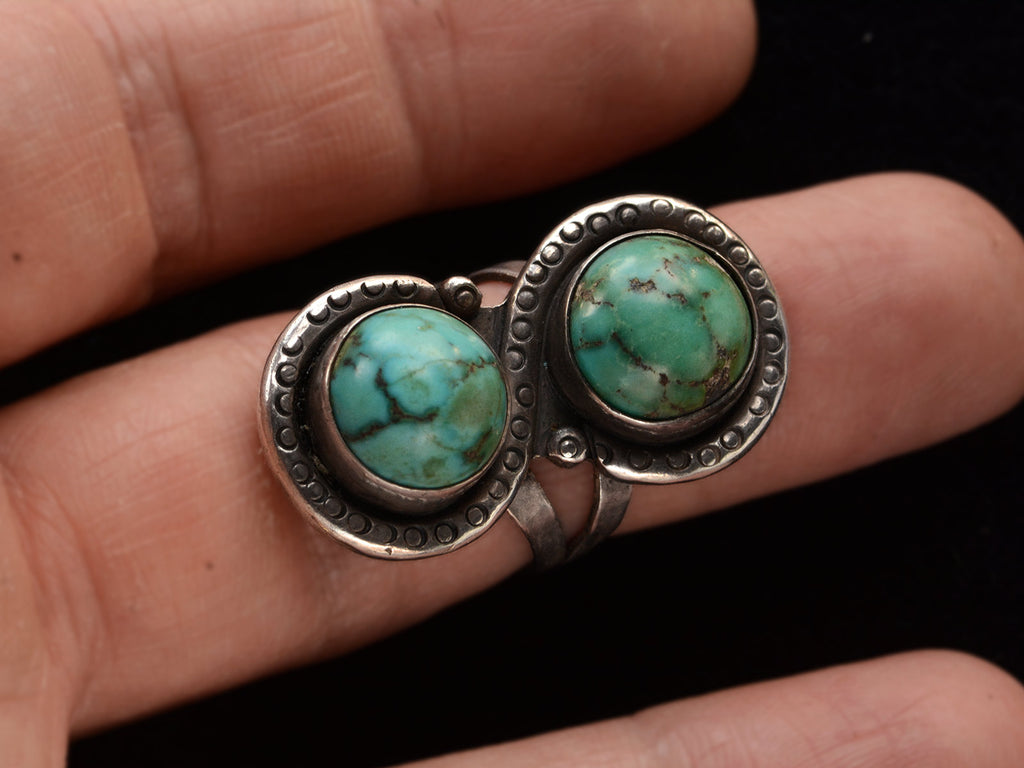 Front view of Silver ring with two turquoise stones on finger