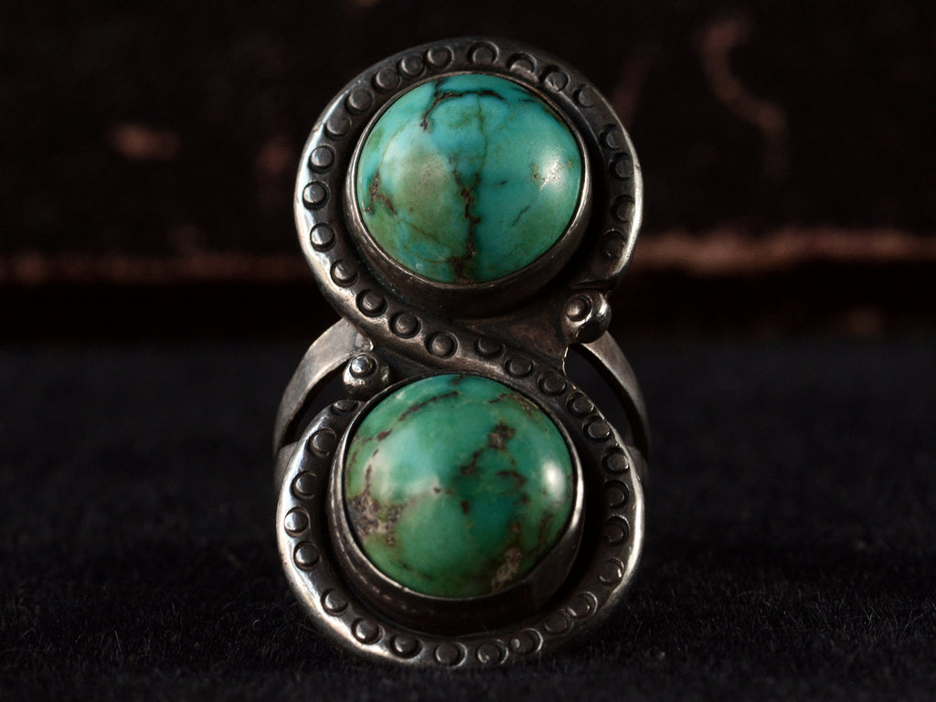 Front view of Silver ring with two turquoise stones on a black background

