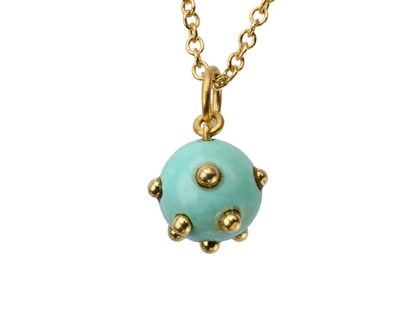 Vintage turquoise pendant studded with gold beads, hanging on chain against white background.