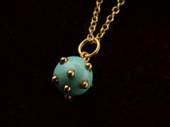 thumbnail of Vintage turquoise pendant studded with gold beads, hanging on chain against black background.