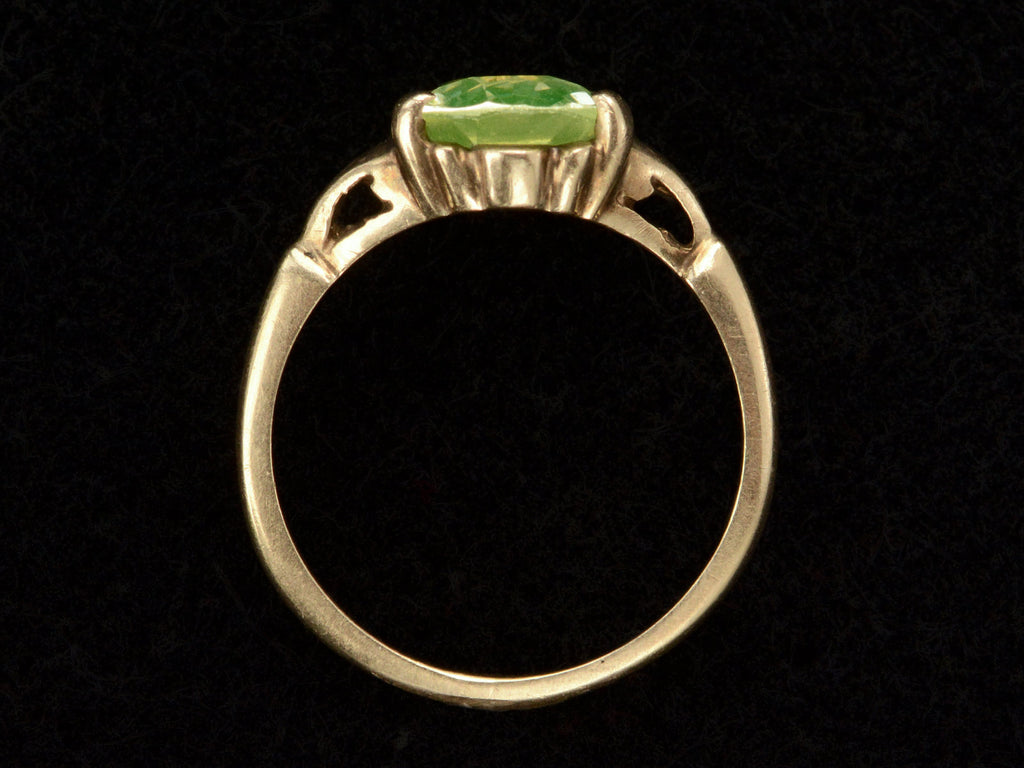 Side profile of Art Deco ring with oval pale green stone set in rosy-yellow gold, shown on black background.