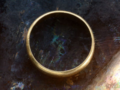 thumbnail of Side profile of c1920 Wide 18K yellow gold wedding band with edge detailing on dark background.