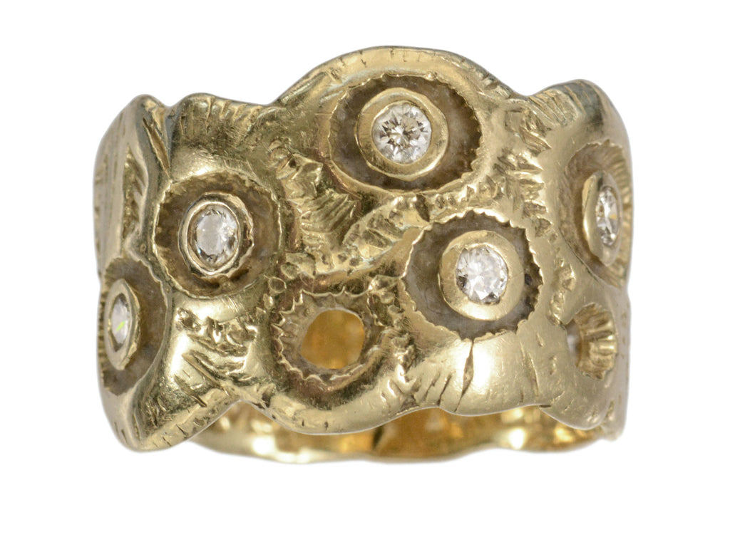 A wide organically form 18k yellow gold band set with randomly placed diamonds, shown on white background.