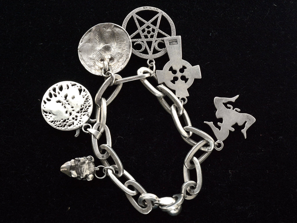 Reverse side of vintage sterling silver charm bracelet. Stamps on charms faintly visible include "STERLING" and "925"
