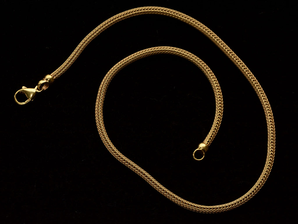 c1980 Woven 18K Yellow Gold Necklace Chain, shown spiraled on black background